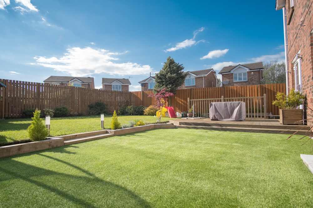 large backyard with artificial grass for a hassle-free living