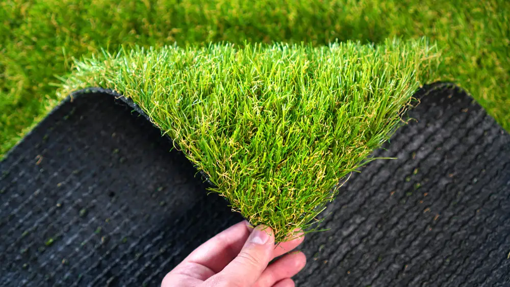 Hand holding an artificial grass roll