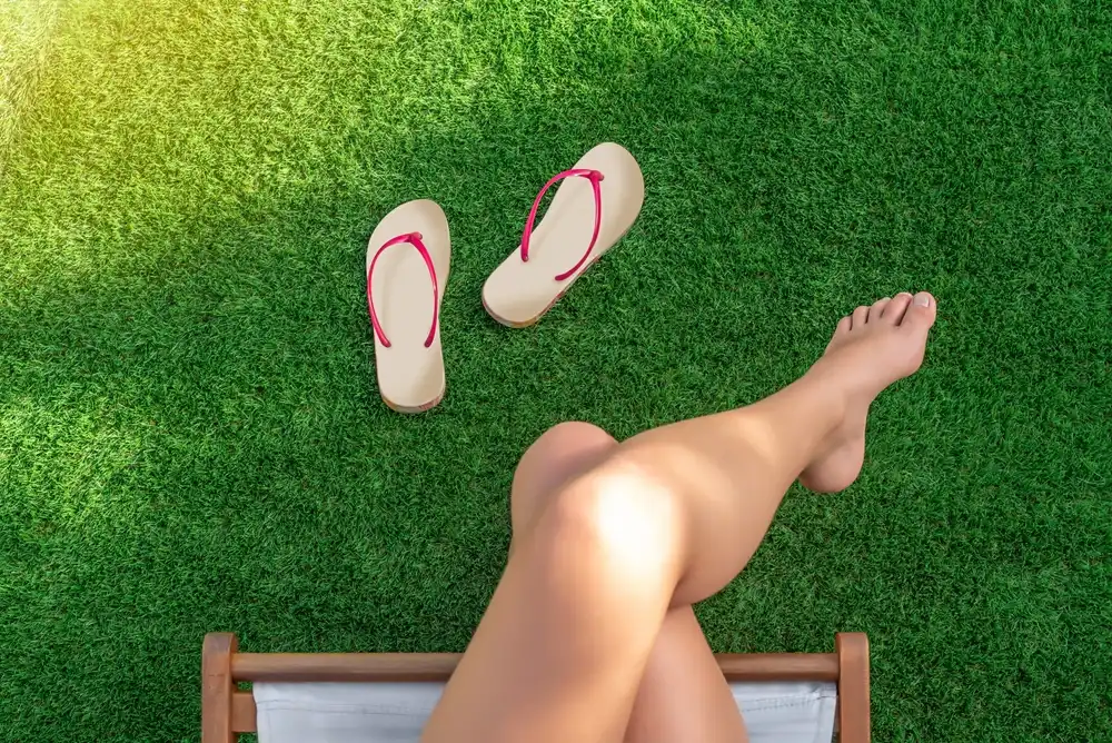 artificial turf with bare feet and flip-flops on the grass