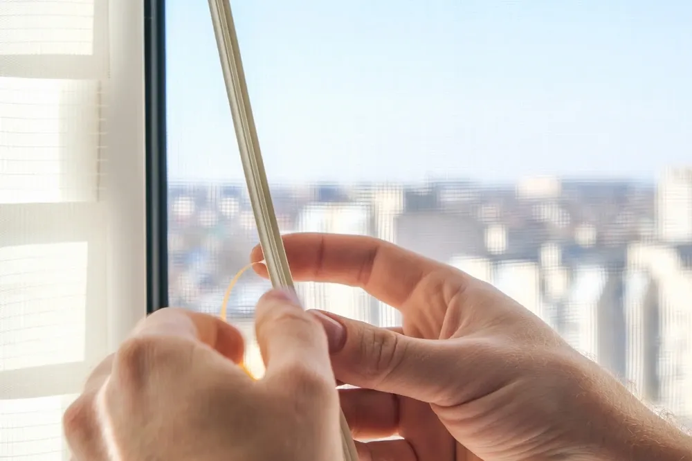 hans applying weatherstipping to a window